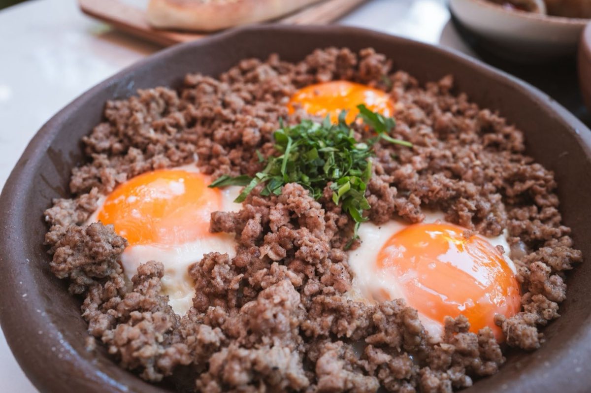 Faten's Bayd Bil Awarma — Eggs cracked into a pan of rendered awarma