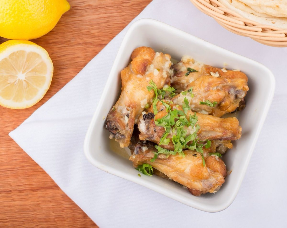 Djaj bil Limoun — Bone-in chicken pieces braised low and slow with preserved lemon, garlic, green olives, and white wine until