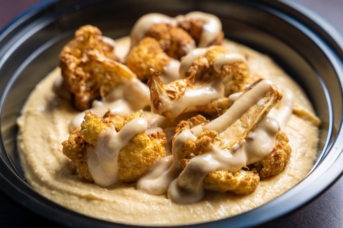 Fried Cauliflower with Tahini — Cauliflower florets fried until deeply golden and caramelized, then arranged on a pool of lemony tahini sauce