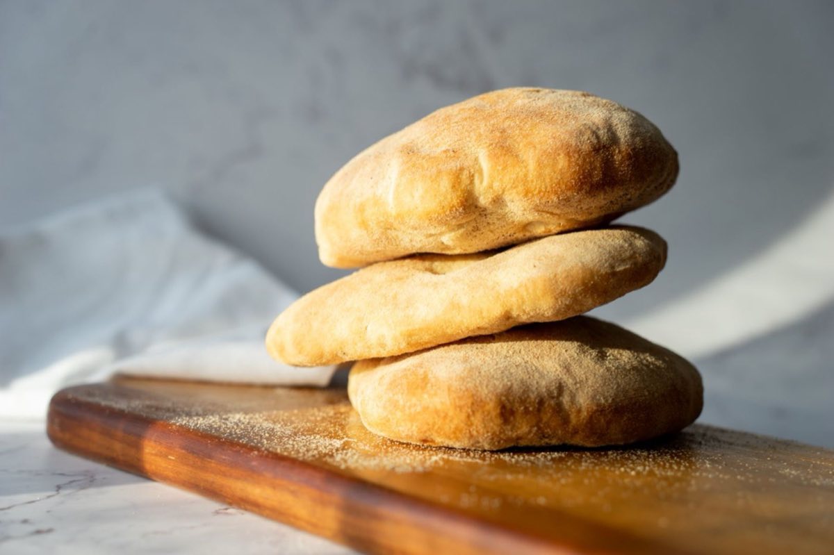 Khubz Arabi — Authentic Lebanese pita bread: thin, pale, and baked at fierce heat so the steam inside creates the perfect