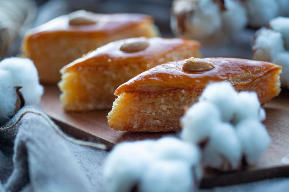 Namoura — Dense semolina cake soaked through with fragrant rose water syrup, topped with a single blanched almond on