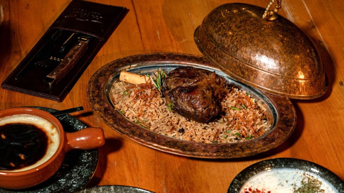 Ouzi — Slow-Roasted Whole Lamb over Spiced Rice — A whole young lamb slow-roasted until the meat falls from the bone in tender sheets, served over a fragrant
