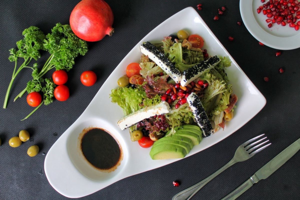 Salatet Avocat — Avocado, pomegranate arils, fresh mint, and toasted pine nuts dressed in lemon and olive oil
