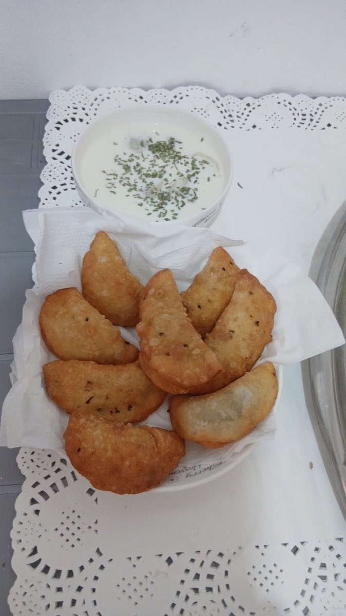 Sambousek — Golden half-moon pastries, sealed with a decorative rope-like crimp, filled with either spiced lamb or