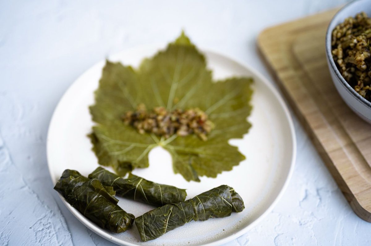 Waraq Dawali bil Lahmeh — Plump grape leaves stuffed with spiced lamb and rice, tightly rolled and braised in a bright lemon broth