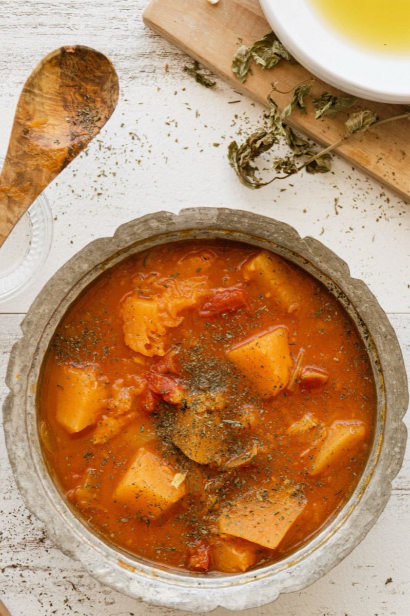 Yakhnit Batata — Golden-fried potato chunks simmered in a savory tomato stew fragrant with coriander and garlic